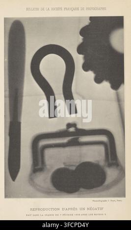 Radiographie (présumée) d'un portefeuille, page, impression photomécanique, inscription : 'Reproduction d'après un négatif, les rayons Royer, photographe, fabricant de clichés, Nancy, papier, collotypie, impression photographique, hauteur 181 mm x largeur 120 mm, examen radiographique, bourse, sac à monnaie., Une image verticale en niveaux de gris montrant des formes en silhouette sur un fond plus clair, comprenant une forme longue et étroite en forme de lame le long du bord gauche, un grand objet en forme de U près du centre, un profil en dents de scie en forme d'engrenage en haut à droite, un cadre rectangulaire aux coins arrondis et une fermoir près du centre inférieur, et deux cercles se chevauchant Banque D'Images
