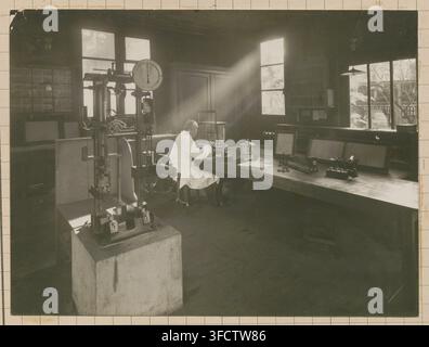 Un scientifique dans un laboratoire à Nogent-sur-Marne, en France, étudiant les propriétés physiques et mécaniques des bois coloniaux, entouré d'équipement scientifique, dans les années 1930, dans le cadre du service technique de l'Institut national d'agronomie coloniale. Banque D'Images