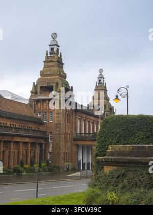 Vue du bâtiment principal historique de l'Université de Glasgow avec ses tours emblématiques et son architecture en grès rouge sous un ciel nuageux à Glasgow, Écottl Banque D'Images