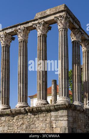 Vue du temple romain d'Évora avec ses anciennes colonnes corinthiennes se dressant contre un ciel bleu clair à Évora, Distrito de Évora, Portugal. Banque D'Images