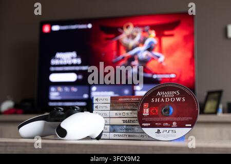 BRECHT, BELGIQUE – 28 août 2026 : Portrait rapproché d'une pile de jeux PS5, d'une manette, d'un disque physique de jeu PlayStation et d'un écran d'accueil flou Banque D'Images