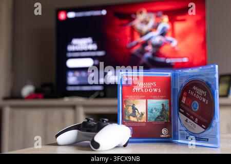 BRECHT, BELGIQUE – 28 août 2026 : Portrait rapproché d'un boîtier de jeu PS5 ouvert avec un disque de jeu physique à l'intérieur et une manette posée à côté Banque D'Images