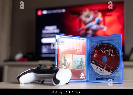 BRECHT, BELGIQUE – 28 août 2026 : Portrait d'un boîtier de jeu PS5 ouvert avec un disque de jeu physique à l'intérieur et une manette PlayStation 5 posée à côté Banque D'Images