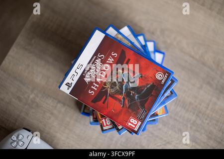 BRECHT, BELGIQUE – 28 août 2026 : Portrait d'une pile de jeux Playstation PS5 avec une manette Playstation posée à côté sur une table, mettant en valeur Banque D'Images