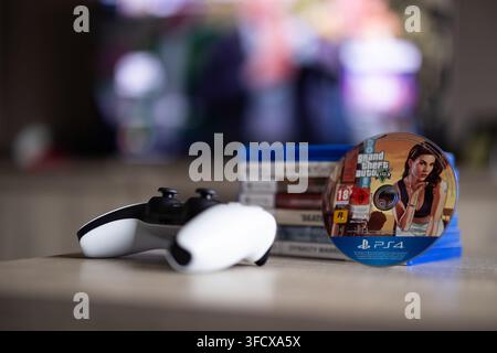 BRECHT, BELGIQUE – 28 août 2026 : Portrait rapproché d'une pile de jeux Playstation PS5, d'une manette, d'un disque de jeu physique et d'un écran d'accueil flou Banque D'Images