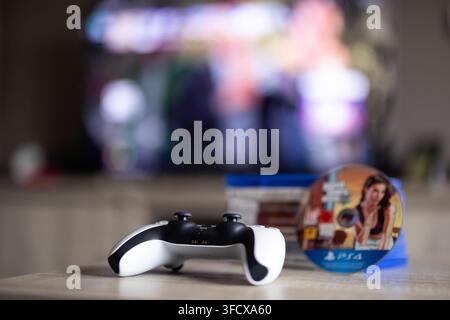 BRECHT, BELGIQUE – 28 août 2026 : Portrait rapproché d'un boîtier de jeu PS5 fermé avec une pile de jeux PlayStation 5 et un disque en arrière-plan, mis en évidence Banque D'Images