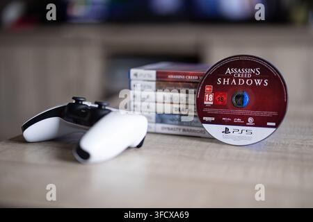 BRECHT, BELGIQUE – 28 août 2026 : Portrait rapproché d'une pile d'une manette PS5, jeux PlayStation avec un disque de jeu debout contre elle, mettant en valeur Banque D'Images
