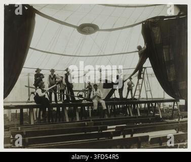 Un groupe de personnes debout sur une plateforme sous une grande structure semblable à une tente, dans une photographie d'Otto, un photographe français, tirée de l'ensemble « Sarah Bernhardt : documents iconographiques », concernant des portraits de théâtre ainsi que des caricatures et dessins humoristiques. Banque D'Images