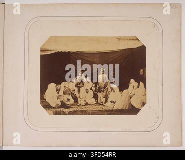 Un groupe de personnes assises sous une structure semblable à une tente, dans une photographie de Félix Jacques Antoine Moulin, un photographe français, prise entre 1856 et 1875, lors de la conquête française de l'Algérie. Banque D'Images