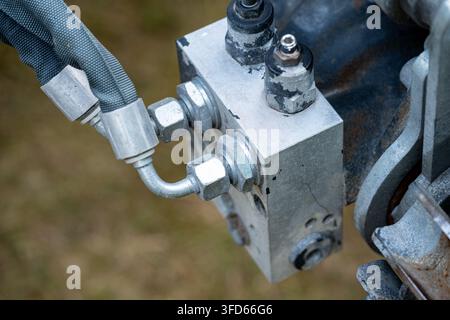 Grossissement d'un bloc de vanne hydraulique, des connexions de tuyau et des raccords sur une plateforme de travail aérienne. Vue détaillée des composants hydrauliques industriels utilisés Banque D'Images