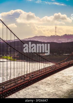 Trafic traversant le Golden Gate Bridge avec les collines de San Francisco et la tour Sutro visibles au loin. Banque D'Images