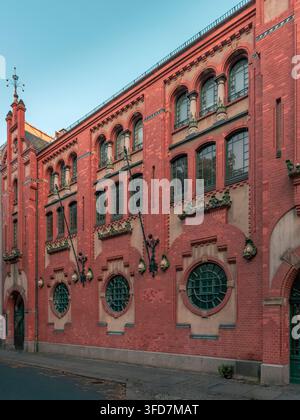 Façade historique en briques rouges avec des fenêtres cintrées et des ornements en pierre dans le paysage urbain de Berlin Banque D'Images