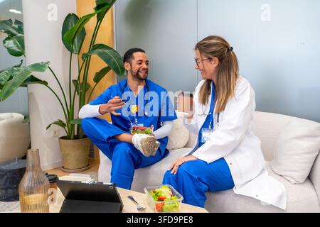 Professionnels de la santé profitant d'une pause déjeuner saine et discutant Banque D'Images