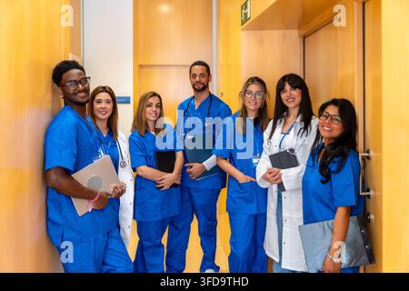 Équipe médicale diversifiée debout dans le couloir de l'hôpital en souriant Banque D'Images