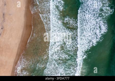 Vue aérielle de dessus des vagues se brisant sur la plage avec une eau océanique claire dans les Outer Banks Banque D'Images