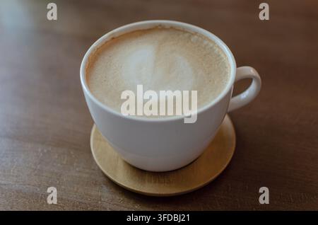 Tasse de cappuccino frais avec mousse crémeuse sur une table en bois Banque D'Images