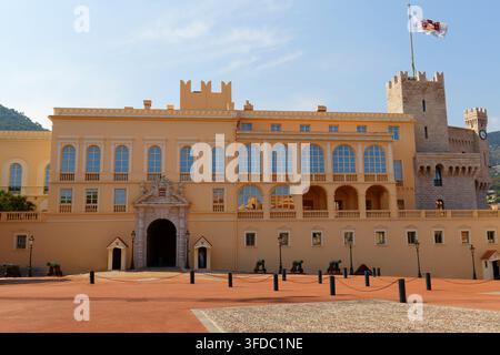 Palais des Princes de Monaco, une façade ocre majestueuse avec une tourelle médiévale, des canons et une garde cérémonielle sur la place du palais. Banque D'Images