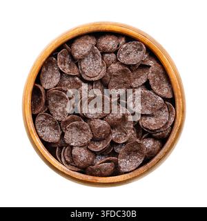 Pépites de chocolat, céréales de petit-déjeuner croustillantes dans un bol en bois, isolées par-dessus. Aliment de blé croustillant fait de farine de blé torréfiée, de poudre de cacao et sucré. Banque D'Images