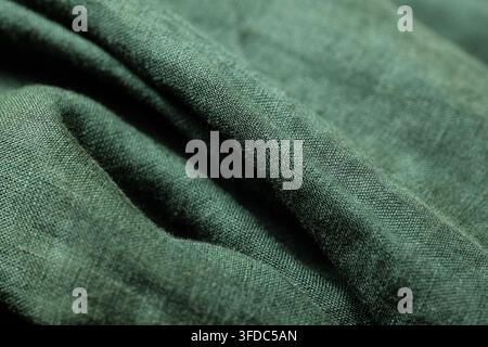 Tissu en lin vert présentant une texture froissée avec des plis naturels et des ondulations douces Banque D'Images
