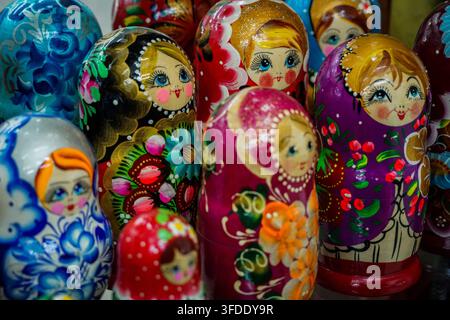 Une vue rapprochée montre une collection vibrante de plusieurs poupées russes Matriochka en bois, chacune peinte à la main avec des motifs floraux et de baies complexes Banque D'Images