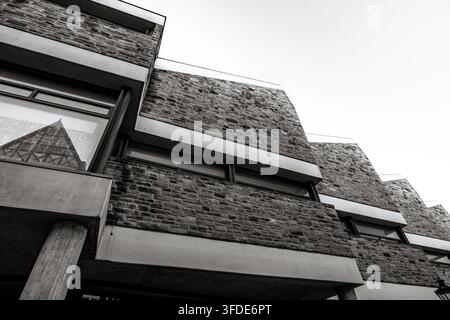 Détail architectural en noir et blanc pris en contre-plongée d'un bâtiment brutaliste en brique et béton dans le centre-ville de Hanovre. Banque D'Images