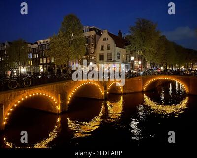 Les lumières soulignant les arches des ponts du quartier Jordaan d'Amsterdam sont illuminées la nuit Banque D'Images