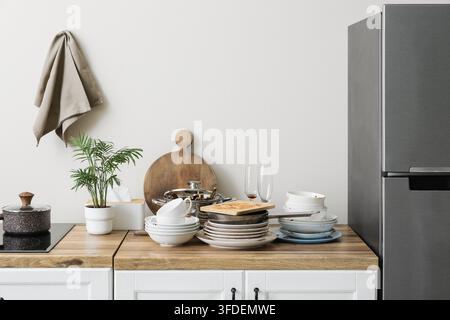 Tâches ménagères et épuisement domestique, pile de vaisselle sale et comptoir de cuisine en désordre avec des ustensiles de cuisine non lavés dans un intérieur moderne Banque D'Images