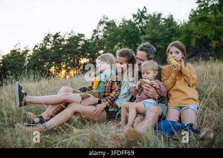 Famille en randonnée ensemble à travers la campagne lors d'un voyage de camping estival. Banque D'Images