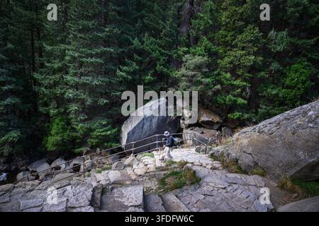 Randonneur descendant une route en lacets escarpée depuis la chute Vernal. Sentier de la Brume dans le parc national de Yosemite. Californie. États-Unis. Banque D'Images