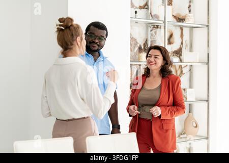 Des collègues divers en discussion dans un bureau moderne et lumineux Banque D'Images