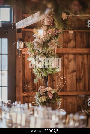 Arrangement floral rustique pour un mariage dans une grange sur une poutre en bois Banque D'Images