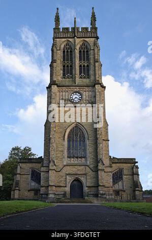 Vue symétrique frontale du grand tour en pierre et de l'entrée de l'église Saint-Thomas et Saint-Jean à Radcliffe, Lancs, Royaume-Uni, sous un ciel nuageux. Banque D'Images