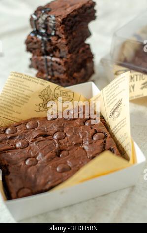 Vue de dessus de morceaux de brownie au chocolat fondant disposés sur une surface légère et texturée. Banque D'Images