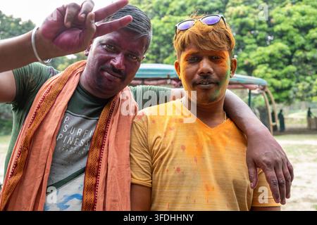 Des amis couverts de couleurs vives de Holi partagent un moment joyeux, embrassant l'esprit du festival des couleurs Banque D'Images