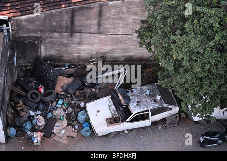 Voiture abandonnée et déversement illégal dans un terrain urbain à Belo Horizonte, Brésil Banque D'Images