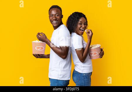 Homme et femme africains insouciants qui mangent du pop-corn Banque D'Images