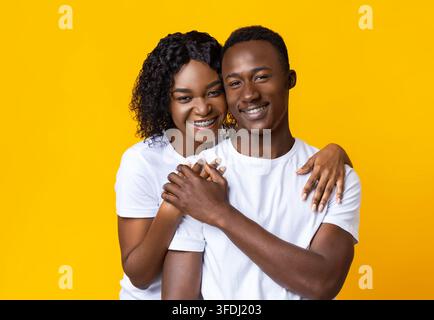 Portrait d'un couple africain aimant posant sur jaune Banque D'Images