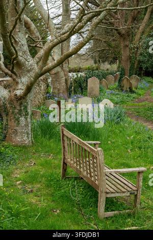 Banc en bois vide et pierres tombales ou tombes sur un cimetière à Freshwater sur l'île de Wight, Royaume-Uni Banque D'Images