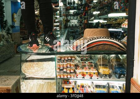 Bogota, Bogota, Colombie – 17 juin 2023 : Vue d’une personne debout sur une vitrine en verre dans une boutique de souvenirs, présentant un sombrero vuelti traditionnel Banque D'Images