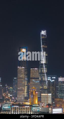 Vue aérienne de l'horizon illuminé de Lujiazui mettant en scène la Tour de Shanghai et une pleine lune se levant derrière les gratte-ciel la nuit à Shanghai, Shanghai Banque D'Images