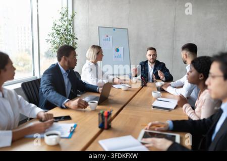 Équipe commerciale multiculturelle ayant une réunion d'entreprise assise dans un bureau moderne Banque D'Images