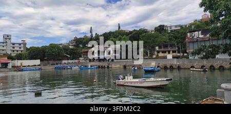 Bateaux de pêche traditionnels ancrés dans un port tranquille le long du front de mer de Tamsui, Nouvelle-Taïwan, Taïwan. Banque D'Images