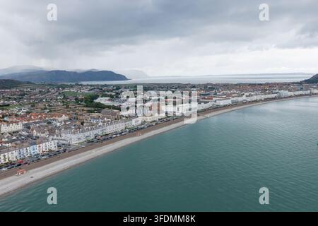 Photo aérienne de Llandudno en été montrant le front de mer du nord du Pays de Galles avec des rangées de bâtiments côtiers, une promenade, une plage de galets, une mer calme entourant la ville Banque D'Images
