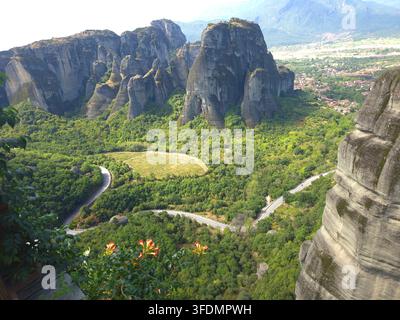 Vue aérienne panoramique des formations rocheuses de Météora et de la route sinueuse entourée d'un paysage verdoyant en Grèce Banque D'Images