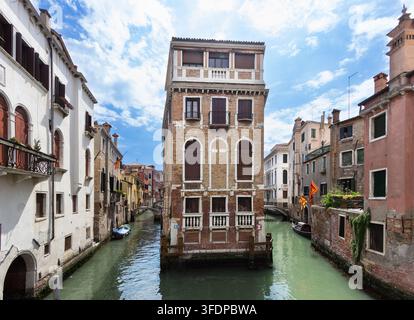 Vue symétrique du Palazzo Tetta à l'intersection du canal du Rio de San Giovanni Laterano à Venise, Italie, entourée d'eau sous un ciel bleu Banque D'Images
