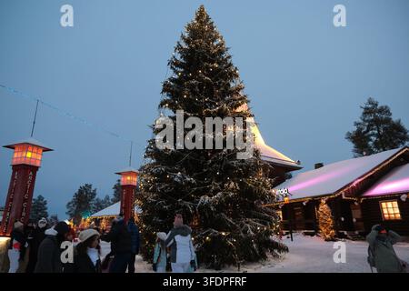 Rovaniemi, Finlande-2 déc. 2025 : immense sapin de Noël illuminé et piliers du Cercle Arctique au crépuscule au Village du Père Noël, Rovaniemi, Finlande Banque D'Images