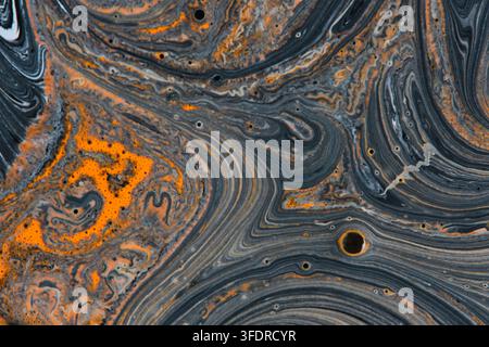Motif abstrait de peinture fluide noire et orange vif tourbillonnant avec des cellules et un mouvement fluide Banque D'Images