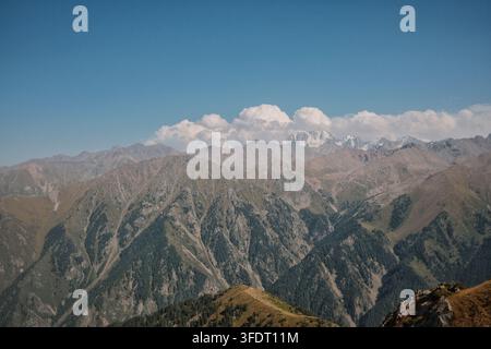 Vue panoramique majestueuse d'une chaîne de montagnes alpines étendue avec des crêtes superposées, des vallées profondes et des sommets enneigés lointains, mettant en valeur l'échelle Banque D'Images