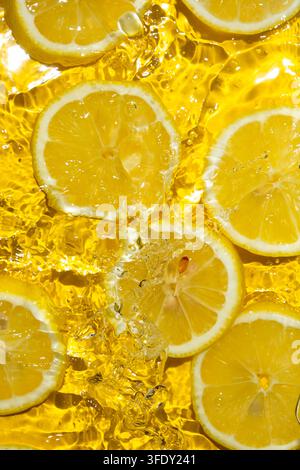 Tranches de citron juteuses dans l'eau vues du dessus Banque D'Images