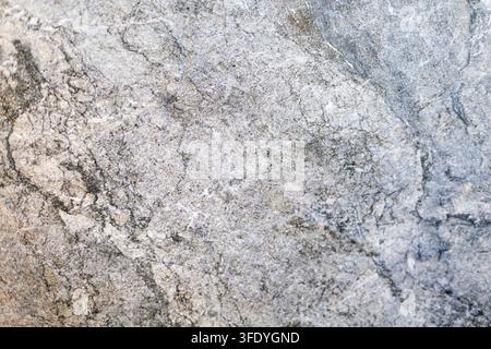 Texture de pierre de marbre gris avec des veines naturelles sombres. Gros plan de pierre de marbre gris avec des veines sombres, des détails marbrés et une texture minérale naturelle. Banque D'Images